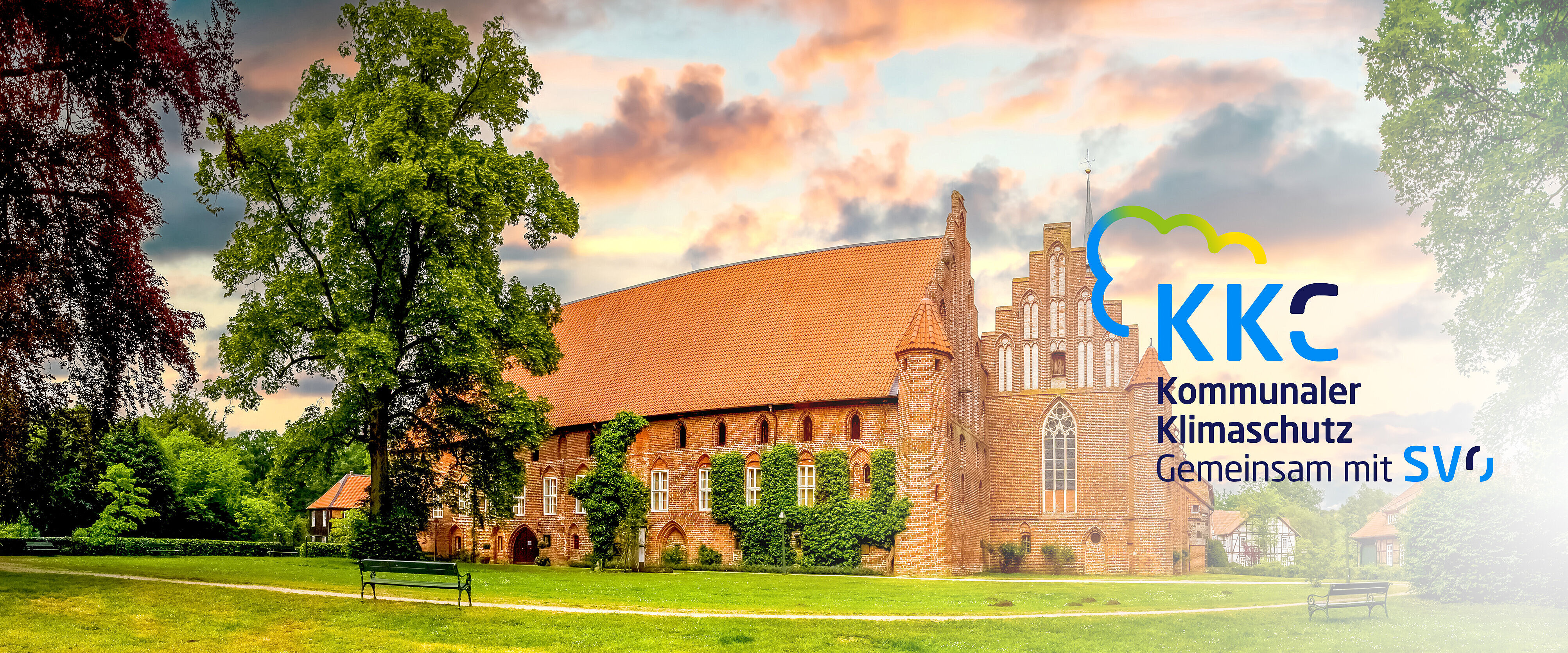 Gloßes Kloster mit Klostergarten und grünen Bäumen.