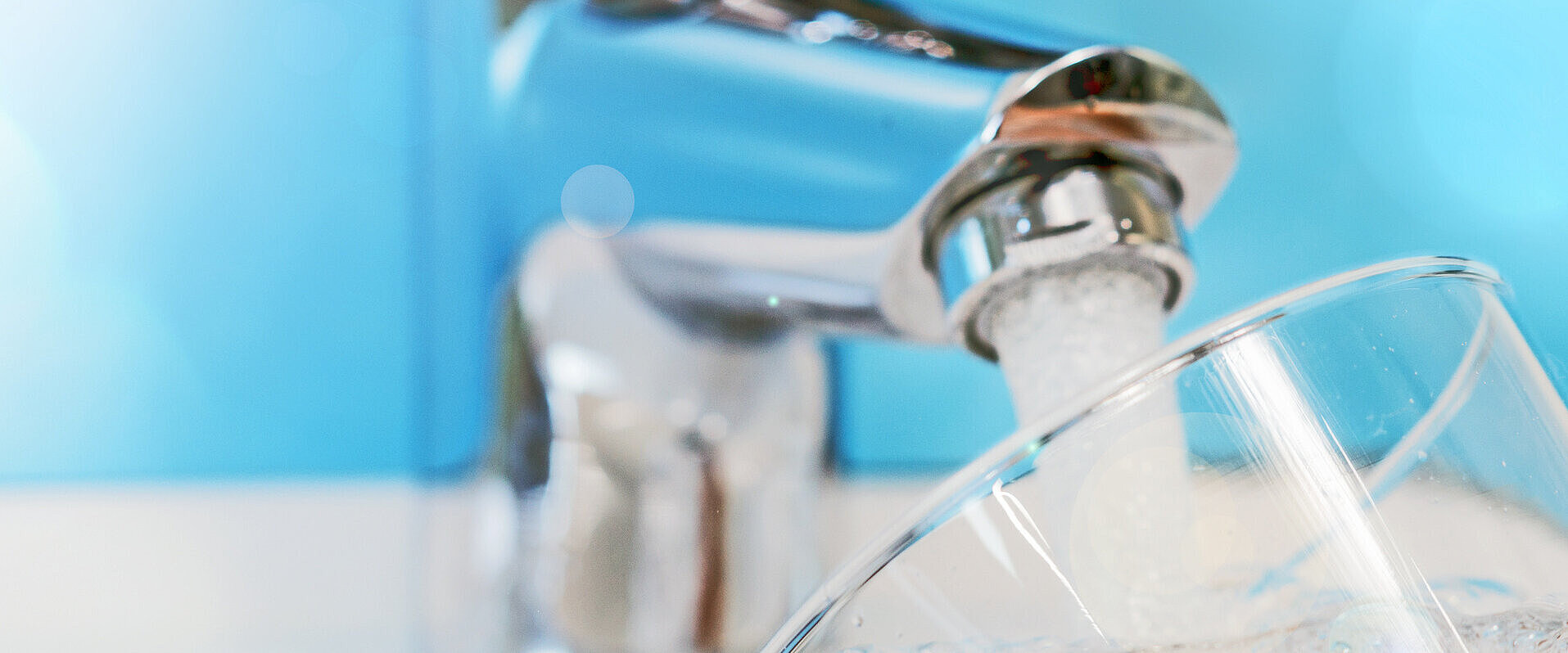 Wasser aus dem Wasserhahn befüllt ein Glas 